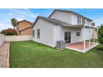Charming backyard with artificial grass, covered patio, and well-maintained exterior, perfect for outdoor entertaining at 8389 Charlton Valley Ct, Las Vegas, NV 89123