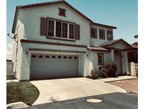 Two-story home featuring an attached two-car garage, neutral stucco and a well-maintained front yard at 8389 Charlton Valley Ct, Las Vegas, NV 89123