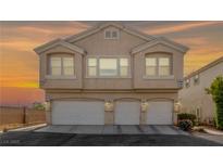 Charming two-story home featuring a triple garage and inviting curb appeal set against a vivid sunset sky at 9312 Straw Hays St # 103, Las Vegas, NV 89178