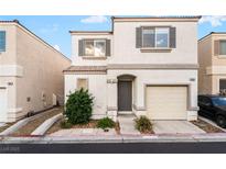 Charming two-story home featuring a tan exterior, well-kept landscaping, and an attached garage at 9962 Keephills St, Las Vegas, NV 89183