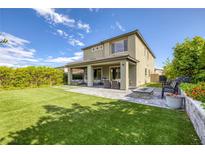 Landscaped backyard featuring artificial turf, fire pit, patio furniture, and mature hedges at 12426 Alpenglow Ct, Las Vegas, NV 89138