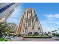 Stunning exterior shot of a high-rise condo building in Las Vegas, Nevada with a circular driveway and manicured landscaping at 135 E Harmon Ave # 1403, Las Vegas, NV 89109
