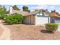 Charming single-Gathering home featuring a two-car garage, complemented by mature trees and desert landscaping at 165 Spinnaker Dr, Henderson, NV 89015