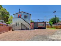 Unique modern two-story home with corrugated metal siding and contrasting orange doors at 1708 Cedar Ave, Las Vegas, NV 89101