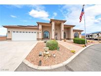 Charming single-story home featuring an arched entrance, desert landscaping, RV parking, and an American flag at 2020 S Omaha Ave, Pahrump, NV 89048