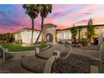 Elegant home featuring a stone tower entrance, lush landscaping, and a beautifully designed walkway leading to the front door at 2181 E Winery Rd, Pahrump, NV 89048