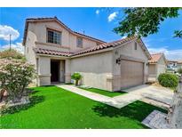 Charming home featuring a two-car garage and well-maintained front yard with a beautiful bush and artificial grass at 3717 Shanagolden St, Las Vegas, NV 89129