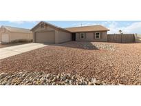 Single-story home with xeriscaped yard, two-car garage and neutral color palette at 383 Virginia Lake Ave, Henderson, NV 89015