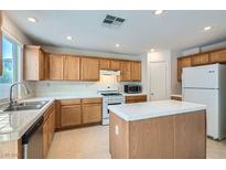 Traditional kitchen featuring wood cabinetry, white appliances and white tile countertops, backsplash and island at 4744 Deer Forest Ave, Las Vegas, NV 89139