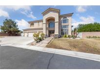 Charming two-story home featuring an arched entryway and a spacious three-car garage at 4883 Grey Mesa St, Las Vegas, NV 89149