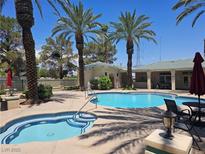 Community pool and spa area featuring palm trees, seating, and well-maintained facilities on a sunny day at 5155 W Tropicana Ave # 2140, Las Vegas, NV 89103