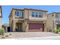 Two-story home featuring a brick driveway, two-car garage, and neutral-toned stucco exterior at 5966 Icicle Falls Ave, Las Vegas, NV 89130