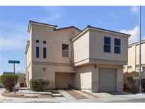 Two-story home boasts a private two-car garage and low maintenance desert landscaping in front at 6117 Daisy Lee Ave, Las Vegas, NV 89108