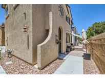 Charming two-story stucco home featuring an arched entryway and landscaped front with a cozy, inviting appeal at 7928 Violet Dawn St, Las Vegas, NV 89149