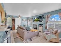 Cozy living room with a fireplace, large windows, and comfortable seating arrangement at 7950 W Flamingo Rd # 1003, Las Vegas, NV 89147
