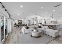 Open living room featuring a large sectional, dining area, and a modern kitchen at 2250 Bowie Cir, Henderson, NV 89014
