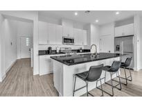 Modern kitchen featuring white cabinets, a sleek black countertop, and stainless steel appliances at 2699 Chance Canyon St, Henderson, NV 89044