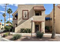Beige condo building featuring a brown framed entry and manicured shrubs at 4151 Sanderling Cir # 351, Las Vegas, NV 89103