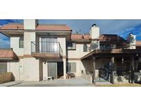 Beige, two-story condo with a red tile roof, balcony, and covered patio at 671 Bourbon St, Pahrump, NV 89048