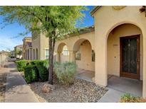 Charming arched entry of a townhome with desert landscaping and a wrought iron security door at 8560 Alocasia Ct, Las Vegas, NV 89149