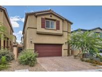 Charming home featuring a two-car garage, complemented by desert landscaping and a brick driveway at 10974 Cheshire Woods Ave, Las Vegas, NV 89166