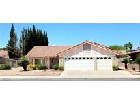 Charming single-story home featuring a red tile roof, three-car garage, and desert landscaping at 1536 Brocado Ln, Las Vegas, NV 89117