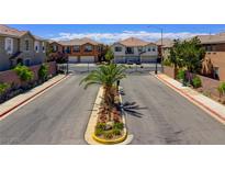 Community street view with palm trees, landscaped median, and gated entry to a neighborhood of modern homes at 23 Hudson Canyon St # 3, Henderson, NV 89012