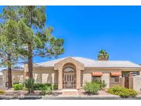 Inviting single-story home featuring a gated entry, mature landscaping, and a neutral color palette at 460 Strawflower Rd, Las Vegas, NV 89107