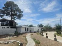 Single story home featuring unique yard art, neutral exterior and a walkway leading to the front door at 6215 Darby Ave, Las Vegas, NV 89146