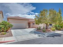 Charming single-story home with a tile roof, mature landscaping, and a spacious driveway leading to an attached garage at 7908 Morning Gallop Ct, Las Vegas, NV 89131
