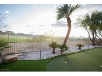 Landscaped backyard featuring a putting green and view of neighboring properties beyond the fence at 9 Knob Oak Dr, Henderson, NV 89052
