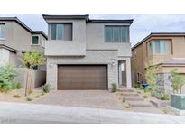 Modern two-story home featuring a brick-accented facade, dark brown garage door, and landscaped front yard at 11840 Pelican Butte Ave, Las Vegas, NV 89138