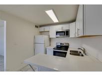 Bright kitchen features white cabinets, stainless steel appliances, and quartz countertops at 212 Orland St # 28, Las Vegas, NV 89107