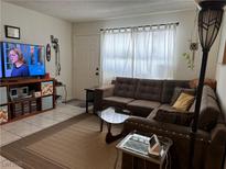Inviting living room featuring a comfortable brown sofa and a large flat-screen TV at 2136 Bavington Dr # A, Las Vegas, NV 89108
