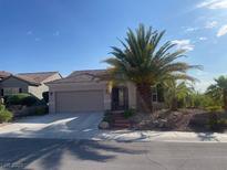 Charming single-story home features a desert landscape, a two-car garage, and a well-maintained front yard at 2221 River Grove Dr, Henderson, NV 89044