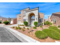 Inviting two-story home featuring an arched entryway, desert landscaping, and a well-maintained lawn on a sunny day at 3425 Bedfordshire Pl, Las Vegas, NV 89129