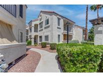 Exterior of a charming stucco home with a tile roof and well-manicured landscaping in a sunny setting at 4860 Nara Vista Way # 104, Las Vegas, NV 89103