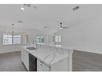 Bright kitchen features a breakfast bar with stunning marble countertops and stainless steel appliances at 5808 Spinnaker Reach Ave, Las Vegas, NV 89130