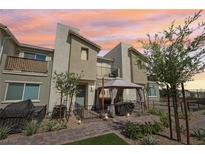 Charming townhome features a cozy patio area with a gazebo, perfect for outdoor dining and relaxation at sunset at 6807 Satin Silver Ct, North Las Vegas, NV 89086