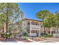 A charming condo with well-maintained landscaping, colorful flowers, and inviting stair access at 7961 Lions Rock Way # 202, Las Vegas, NV 89128