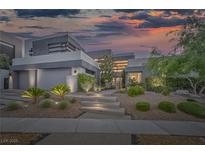 Modern home exterior with landscape lighting, desert landscaping, and a multi-car garage at 1337 Villa Barolo Ave, Henderson, NV 89052