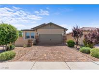 Charming single-story home with well-maintained landscaping and a brick driveway at 2207 Valdina St, Henderson, NV 89044