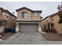 Two-story home with a two car garage, low maintenance landscaping and neutral colored stucco at 5052 Whistling Acres Ave, Las Vegas, NV 89131