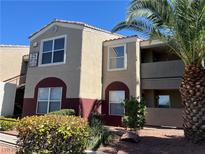 Two-story condominium featuring an attractive paint scheme and a well-maintained landscape, with a mature palm tree at 5055 W Hacienda Ave # 2102, Las Vegas, NV 89118