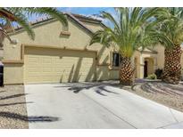 Inviting single-story home with a two-car garage, complemented by palm trees and desert landscaping at 520 Blackbird Knoll Ct, North Las Vegas, NV 89084