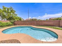 Backyard view of a refreshing pool with a surrounding patio area and privacy wall on a bright day at 5528 Stone Lagoon St, North Las Vegas, NV 89031