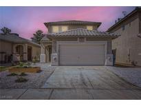 Two-story home with a tile roof, a two-car garage, and low-maintenance landscaping at 5834 Autumn Harvest Ave, Las Vegas, NV 89142