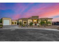 Stunning single-story home showcasing modern architecture with a stone facade and a circular driveway at 7062 Maverick St, Las Vegas, NV 89131