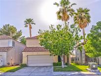 Inviting two-story home featuring a two-car garage and lush greenery and beautiful trees at 8231 Burnt Sienna St, Las Vegas, NV 89123