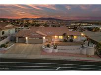 Inviting single-story home featuring a terra cotta roof, desert landscaping, and attached two-car garage at sunset at 1060 Calico Ridge Dr, Henderson, NV 89011